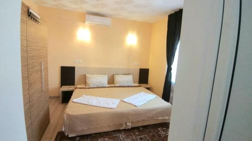 a bedroom with a bed with two pillows on it at Rose & Water Guest house in Pavel Banya