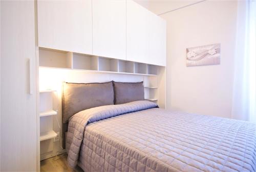 a bedroom with a bed and white cabinets at Casa di Luigi ed Ernestina in Dolcedo