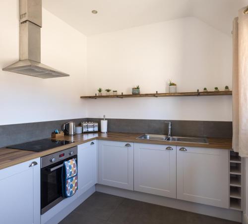 a kitchen with white cabinets and a sink at Clopton Courtyard Cambridge in Cambridge