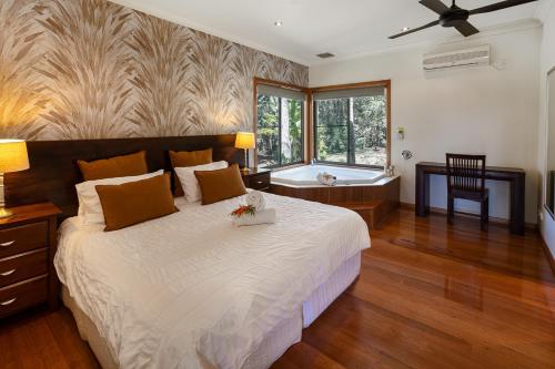a bedroom with a large bed and a large window at Lake Weyba Cottages Noosa in Peregian Beach