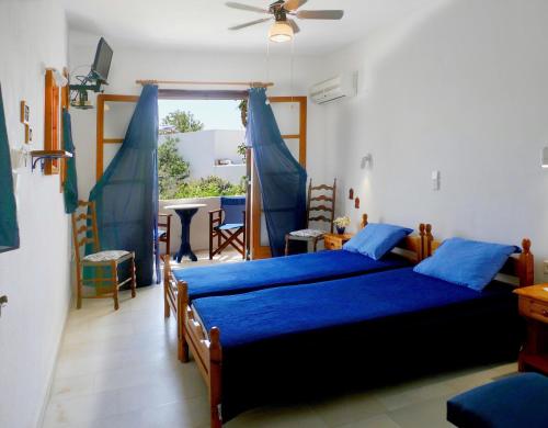 a bedroom with a bed with blue sheets and a window at fi naxos in Agios Prokopios