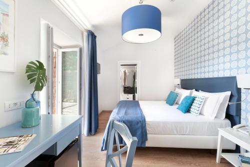 a bedroom with a bed and a table and a desk at Hotel Vista di Capri in Massa Lubrense