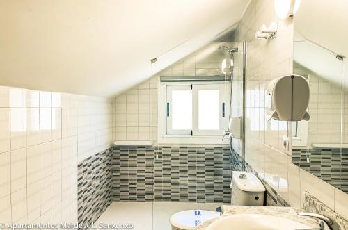 サンシェンショにあるApartamento Mardevelaのバスルーム(洗面台、トイレ付)、窓が備わります。