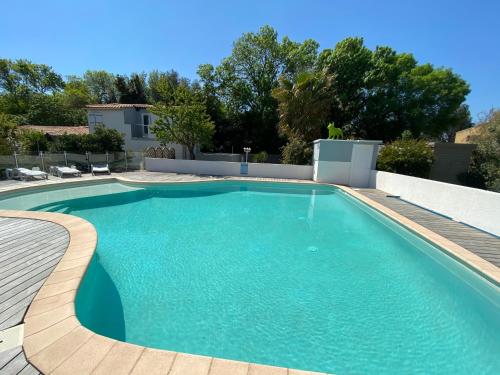 een zwembad met blauw water in een tuin bij Jm Vacances Serignan in Sérignan