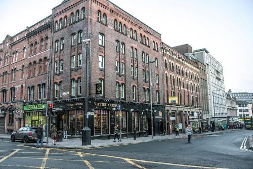 a large brick building on the corner of a city street at Base Serviced Apartments - Sir Thomas Street in Liverpool