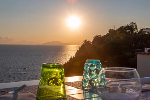 a table with glasses and a view of the ocean at Hotel Vista di Capri in Massa Lubrense