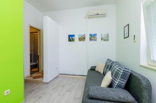 uma sala de estar com um sofá verde e um corredor em Apartments Mali Paradiso em Mlini
