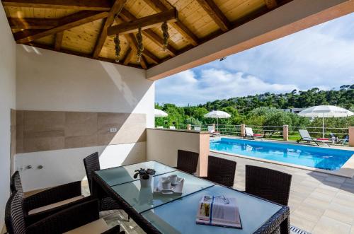 um pátio com uma mesa e cadeiras e uma piscina em Apartments Mali Paradiso em Mlini