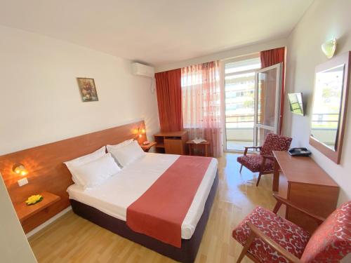 a hotel room with a bed and a desk at Hotel Tomis Neptun in Neptun