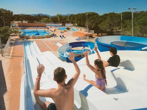 un groupe de personnes assises sur un toboggan dans un parc aquatique dans l'établissement Oasis village, à Puget-sur Argens