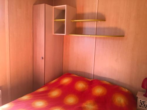 Una habitación con una cama con una manzana. en Oasis village en Puget-sur Argens