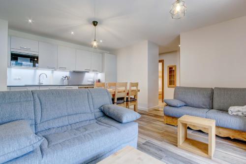 un salon avec deux canapés bleus et une cuisine dans l'établissement Lapia 3, à Morzine