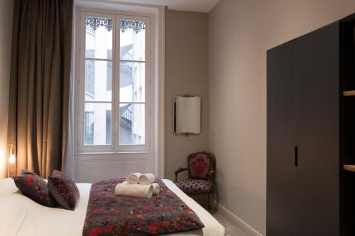 - une chambre avec un lit, une fenêtre et une chaise dans l'établissement ELLA - Magnifique appartement, à Lyon
