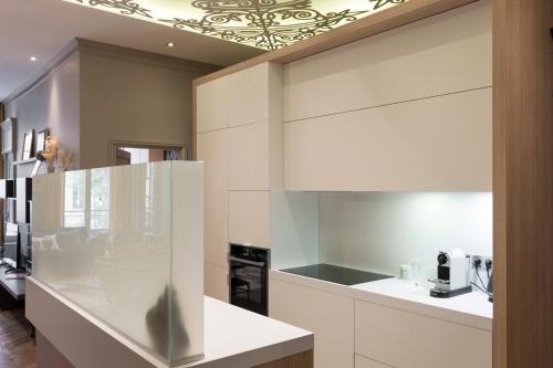 - une cuisine avec des appareils électroménagers blancs et un plafond dans l'établissement ELLA - Magnifique appartement, à Lyon