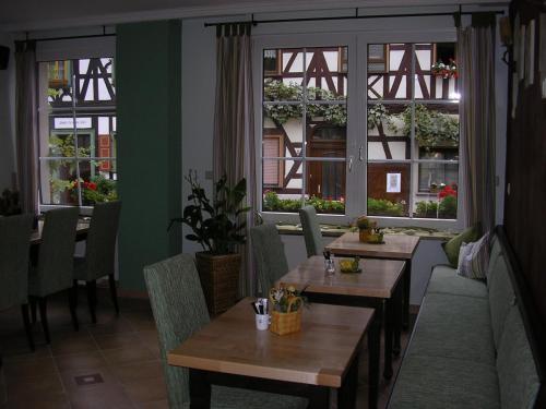 a restaurant with tables and chairs and windows at Gästehaus Wieghardt in Braubach