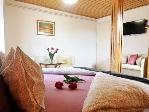 um quarto com uma cama e uma mesa com flores em Balaton Apartman Paloznak em Paloznak