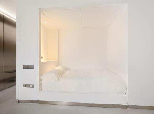 a white room with a bed in a mirror at Rhinoceros in Rome