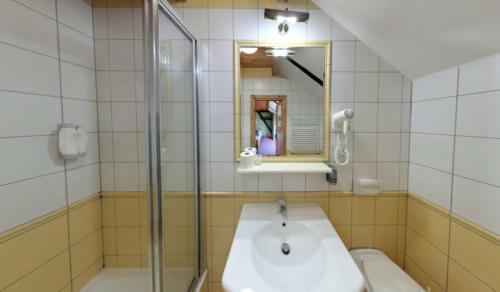 y baño con lavabo y ducha. en Hotel Stara Stajnia, en Pleszew