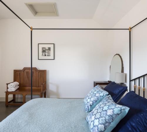 a bedroom with a bed with blue sheets and a table at Clopton Courtyard Cambridge in Cambridge