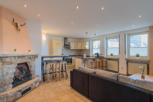 a kitchen and living room with a stone fireplace at Hotel Koch Schilt in Irrel