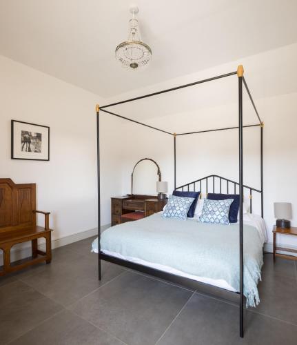 a bedroom with a black canopy bed with blue pillows at Clopton Courtyard Cambridge in Cambridge
