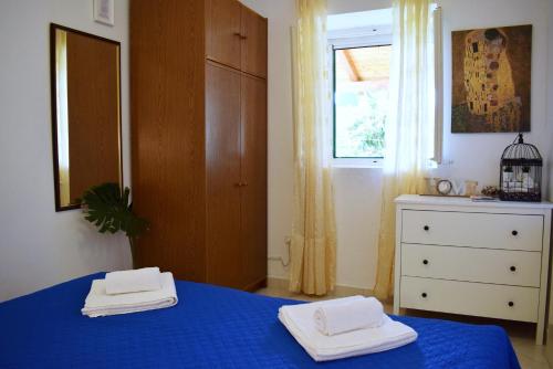 a bedroom with a blue bed with two towels on it at Lina Vranković Apartments in Hvar