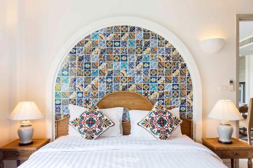 um quarto com uma parede de azulejos marroquinos por cima de uma cama em Chelona Hua Hin by Favstay em Khao Tao