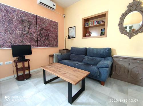 un soggiorno con divano blu e tavolo di Apartment Alacas Sevilla a Siviglia