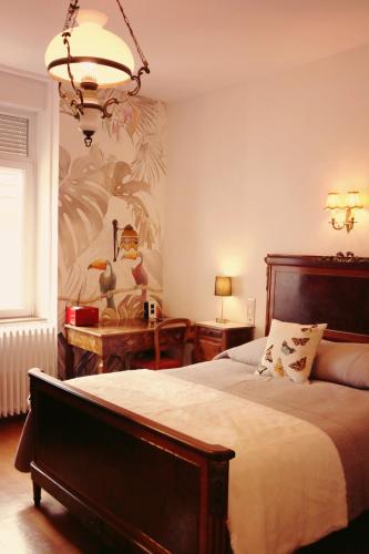 une chambre avec un lit et un lustre dans l'établissement Domaine Gille, à Comblanchien