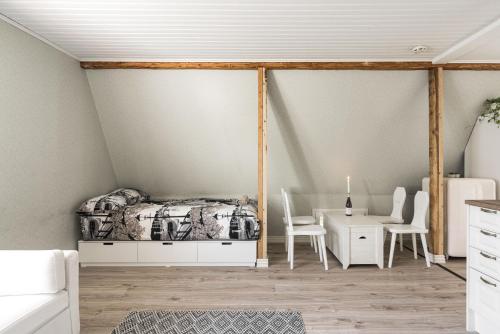a bedroom with a bed and a table and chairs at Newly renovated apartment in a woodenhouse from 1910 in Martti! in Turku