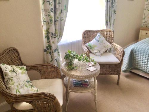 a room with two chairs and a table and a window at The Old House in Nether Stowey