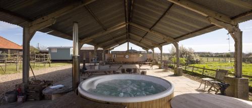 a hot tub in a pavilion with a table and chairs at Clopton Courtyard Cambridge in Cambridge