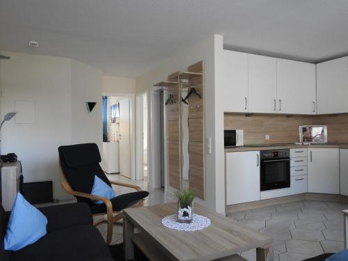 een woonkamer met een tafel en een keuken bij Seemöwe Whg. 8 in Cuxhaven