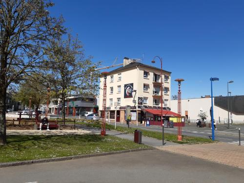 un grand bâtiment blanc dans une rue de la ville dans l'établissement Hotel de Bretagne, à Fougères