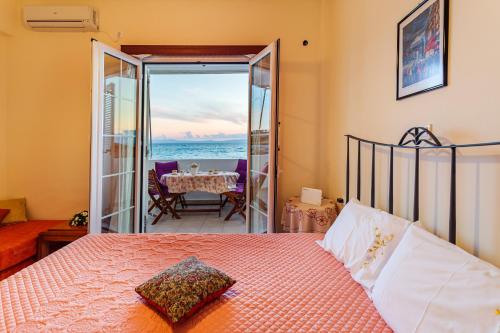 1 dormitorio con cama y vistas al océano en On the Beach - Akroyali Family Lodging, en Akrogiali