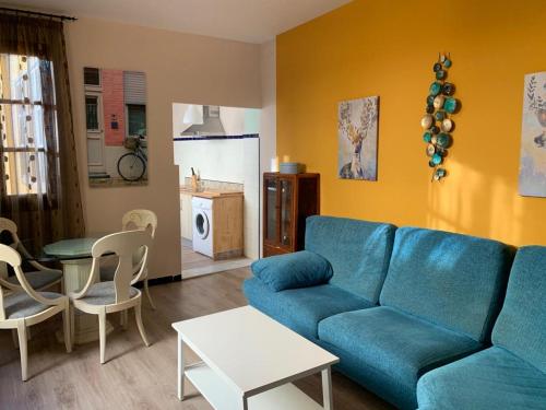 a living room with a blue couch and a table at AIRAM Home ARAGON, 7 in Almansa