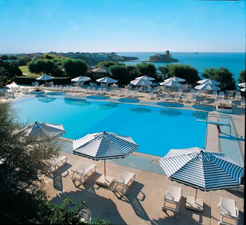 uma grande piscina com cadeiras e guarda-sóis em iGV Club Vacanze Le Castella em Le Castella