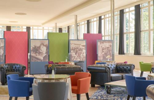 una sala d'attesa con sedie, tavoli e finestre di Bata Club Haus a Möhlin