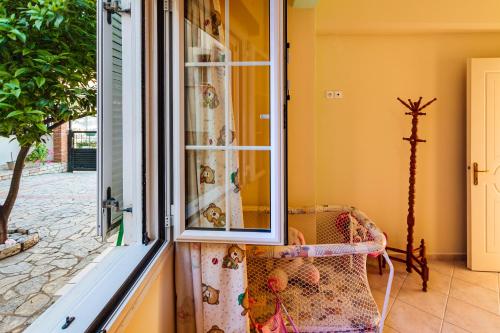 a window in a room with a couch in front of it at On the Beach - Akroyali Family Home in Akrogiali