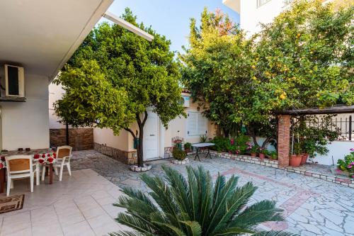 a courtyard with trees and a table and chairs at On the Beach - Akroyali Family Home in Akrogiali