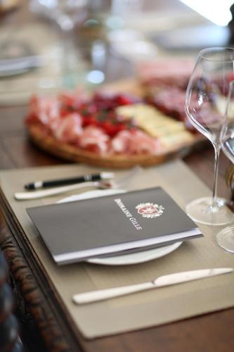 une table avec une assiette de nourriture et un verre de vin dans l'établissement Domaine Gille, à Comblanchien