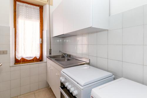 a small kitchen with a sink and a stove at Casa Spiaggia Molo 2 in Isola Rossa