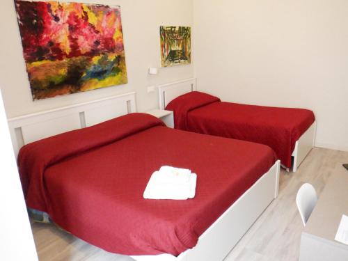 a room with two beds and a painting on the wall at Sicania in Patti