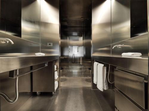 a large stainless steel bathroom with two sinks and towels at Rhinoceros in Rome