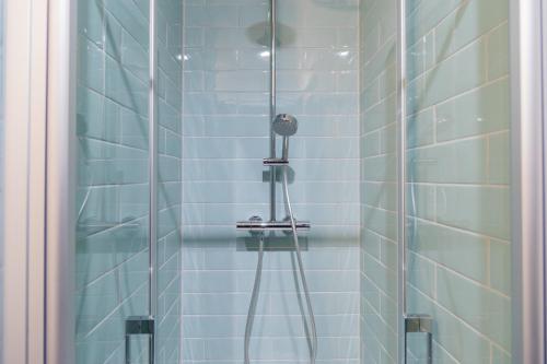 a shower in a bathroom with blue tiles at Nena Apartments Moritzplatz in Berlin