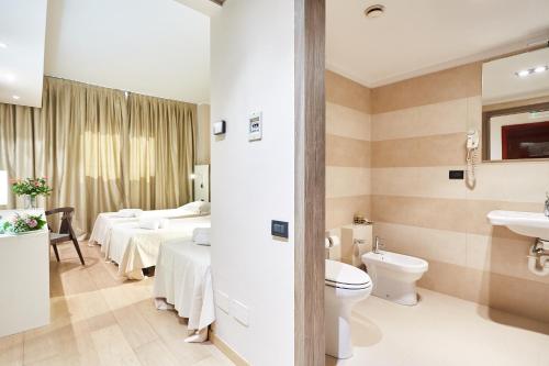 łazienka z 2 łóżkami, toaletą i umywalką w obiekcie Ferretti MajesticHouse w mieście Castenedolo