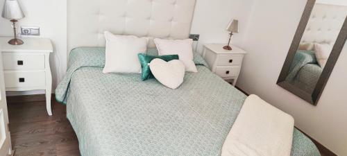 ein Schlafzimmer mit einem Bett mit einem Herzkissen drauf in der Unterkunft Piso 100 metros del Centro del Pueblo 6 kilómetros de la PLAYA La BARROSa in Chiclana de la Frontera