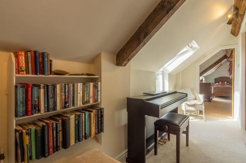 an attic office with a desk and a book shelf with books at Five Acres in Thirsk