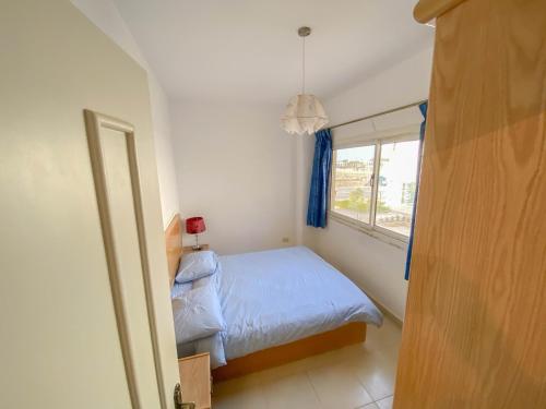 a small bedroom with a bed and a window at The Touristic Promenade Apartment in Hurghada