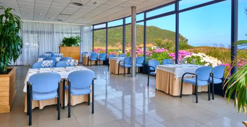 a banquet hall with tables and chairs and flowers at Hotel Juan de la Cosa in Santoña